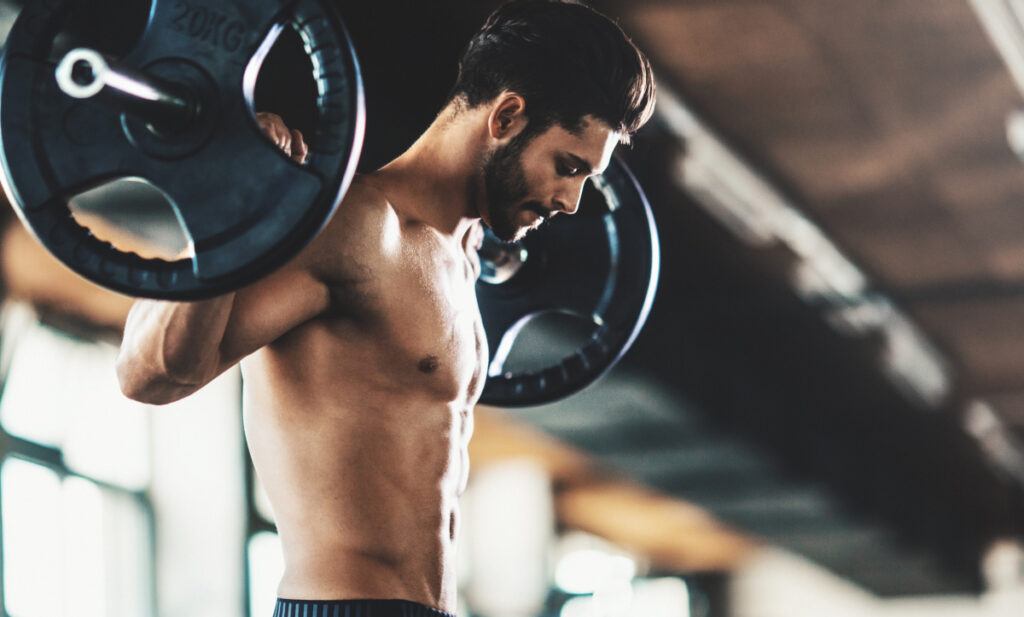 Man Lifting Weights at the Gym Following Tummy Tuck surgery