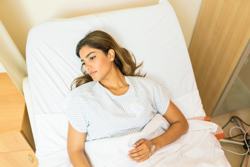Female plastic surgery patient lying in recovery room