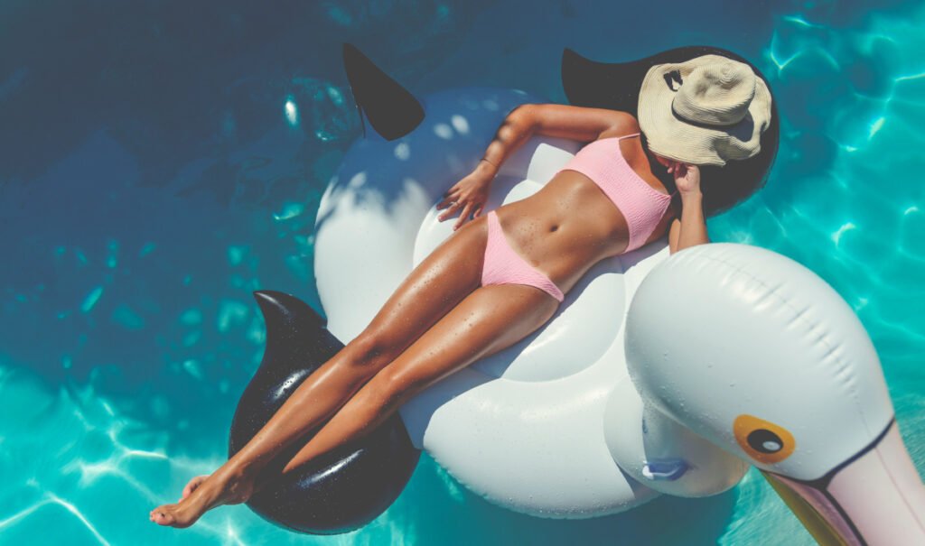 Woman in Bikini Floating in the Pool During Summer