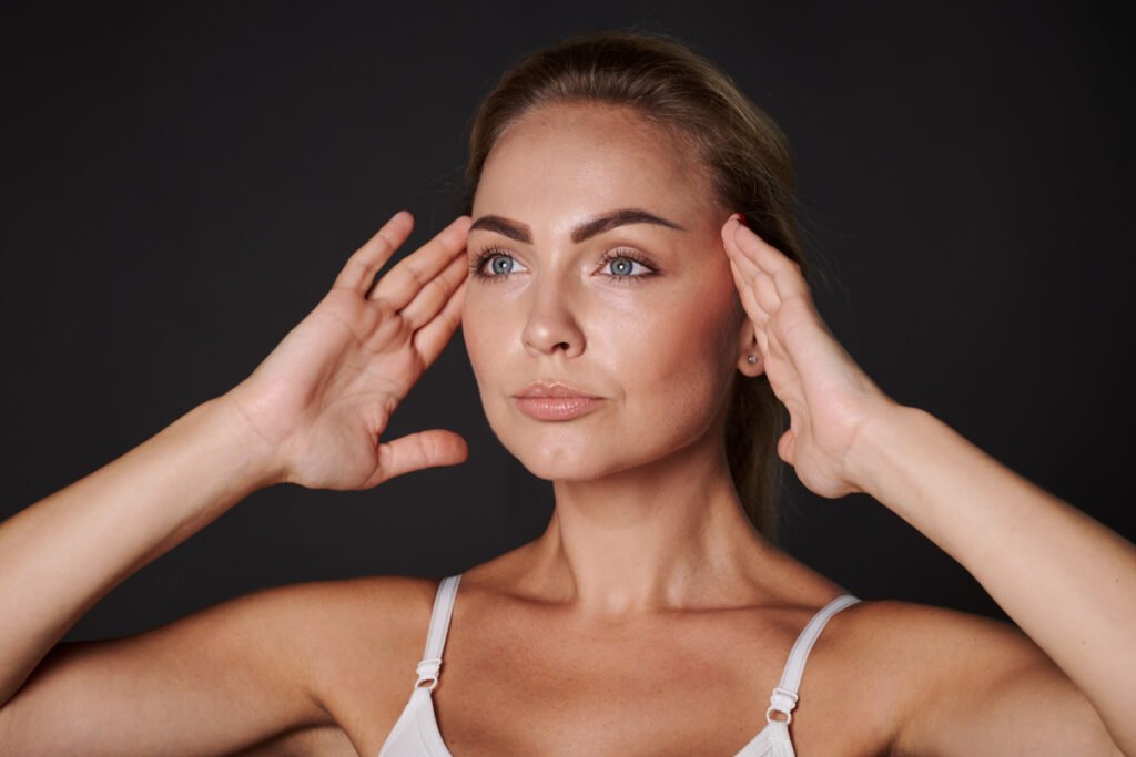 Woman pulling and lifting brows and face