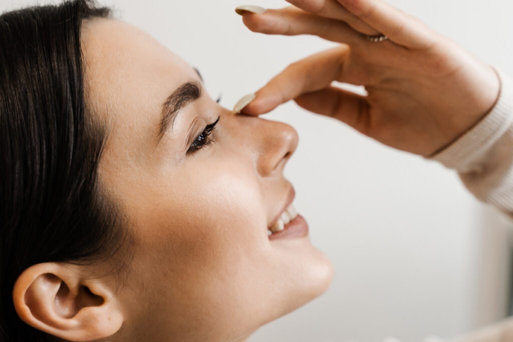 Young woman smiling during a consultation for nose surgery