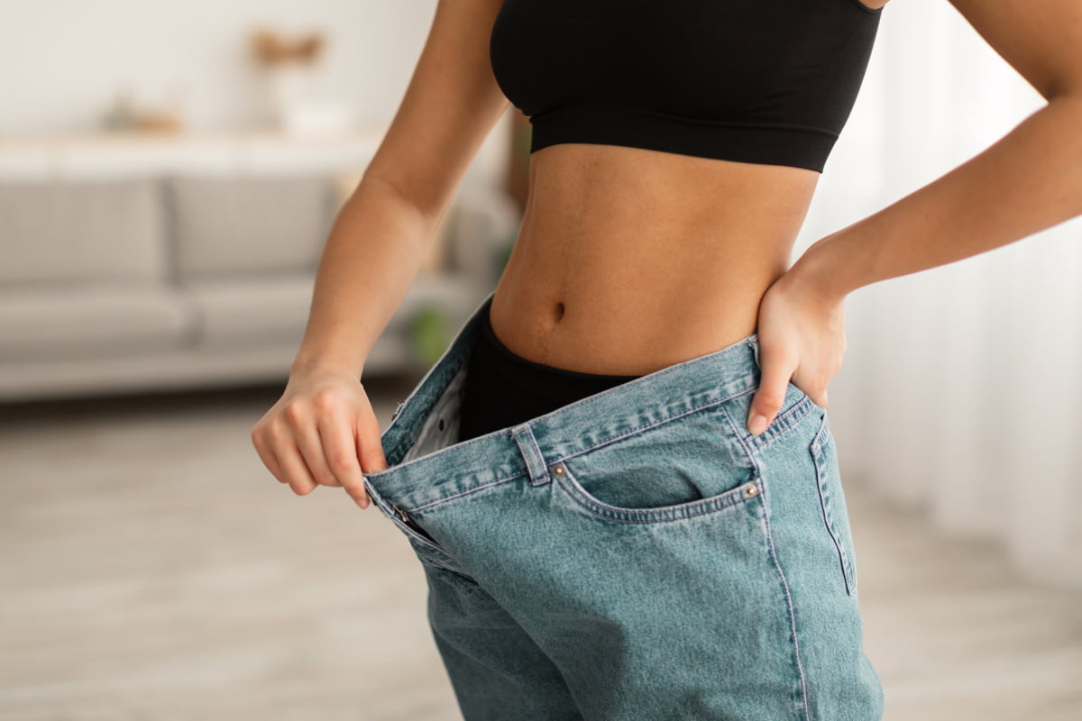 Woman with loose jeans following Houston tummy tuck surgery