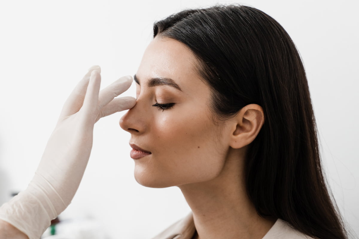 Woman during revision rhinoplasty consultation with facial plastic surgeon